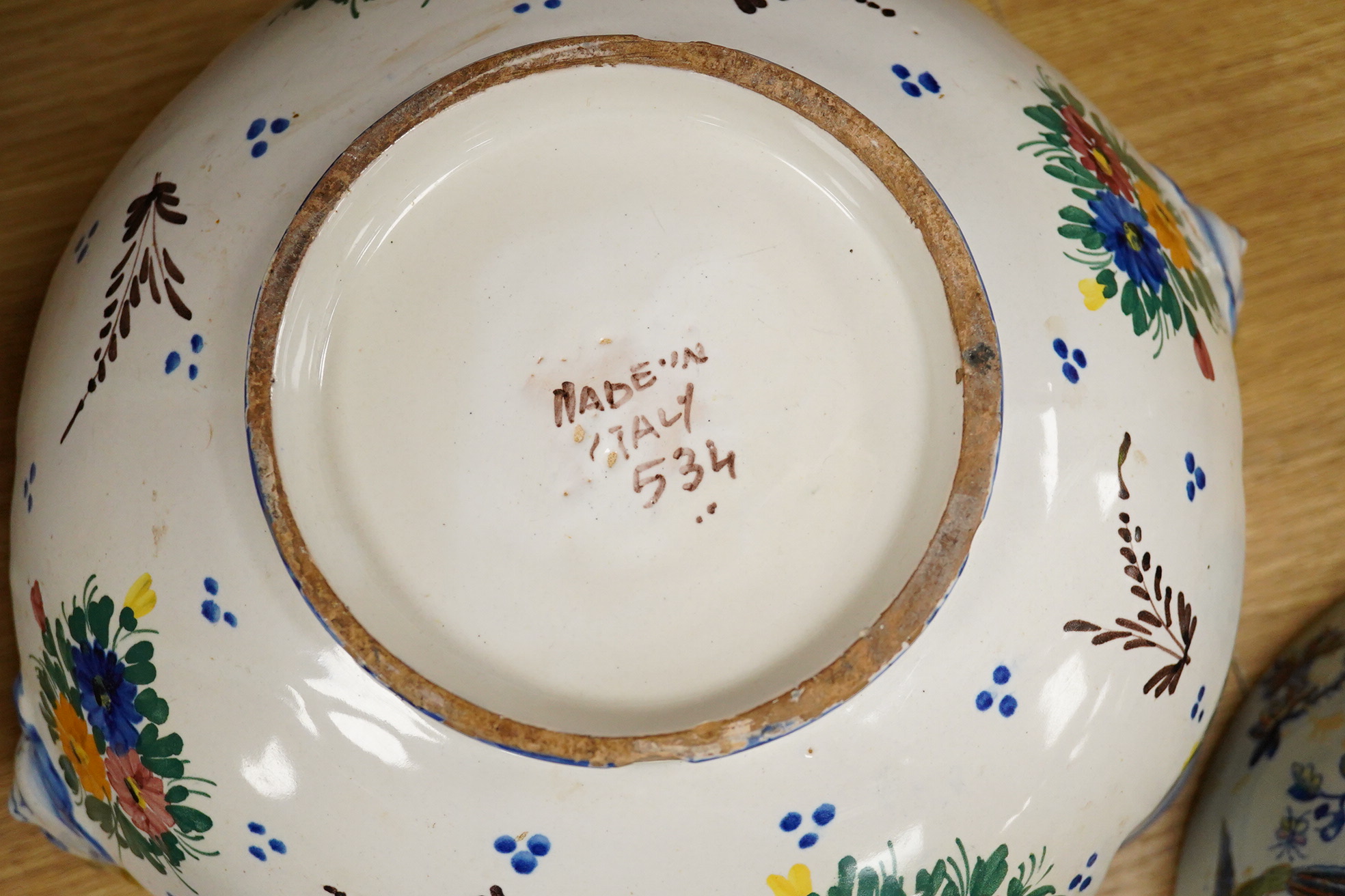 An Italian faience punch bowl painted with flowers and masks and an ironstone pedestal bowl, largest 31cm in diameter